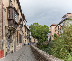 View at the Darro Street, Carrera del Darro to the sad walk, Paseo de los tristes, iconic and picturesque street with classic buidings in Granada, Spain