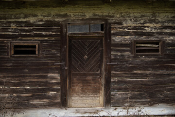 Old wooden rustic doors on rural home wall.