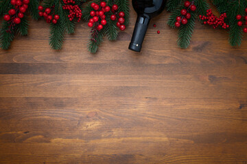 Christmas tree branches and viburnum with bottle of wine and copy space for text on wooden background