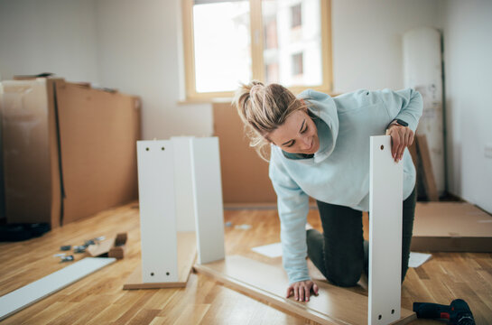 Woman assembling furniture at home 