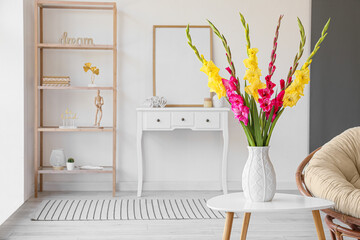 Vase with fresh gladiolus flowers on table in room - obrazy, fototapety, plakaty