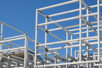 construction of a building. metal framework of a new house on blue sky background. architecture concept
