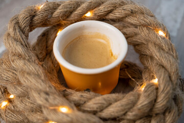 tasse en céramique en forme de gobelet de café dans des cordes éclairées