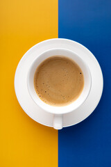 Black coffee in a cup on Ukraine flag blue and yellow background