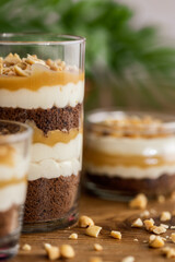 Snickers toffee cream peanut layered dessert in a glass jar on a wooden background