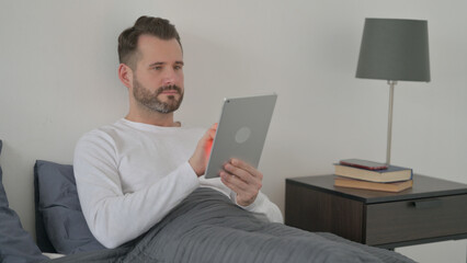 Man using Tablet in Bed