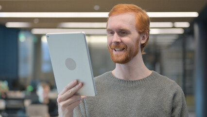 Portrait of Video Call on Tablet by Young Man in Office 