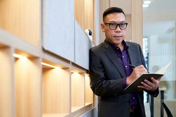 Asian Businessman portraits with pen and note in office