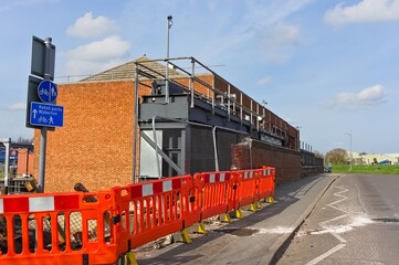 Road barriers in front of damaged wall of bridge after car accident