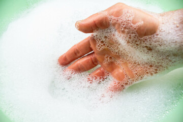 Fototapeta premium Soap foam. Foam in a green basin. Water with foam.