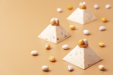 Traditional cottage cheese dessert Paskha decorated with caramel and chocolate candy eggs on pastel background. Modern minimalistic Easter background with copy space for your design.