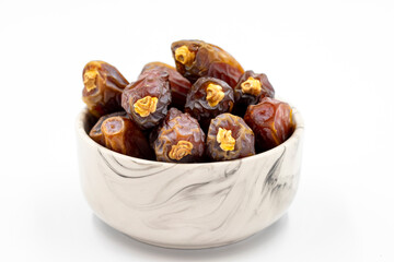 Date fruit isolated on a white background. A bowl of date fruit (Medjoul). close up