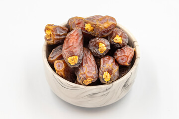 Date fruit isolated on a white background. A bowl of date fruit (Medjoul). close up