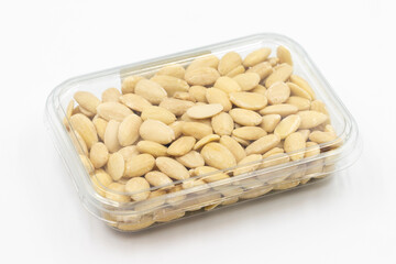 Packed peeled raw almonds on a white background. Peeled raw almonds packaged for sale at the market counter. close up
