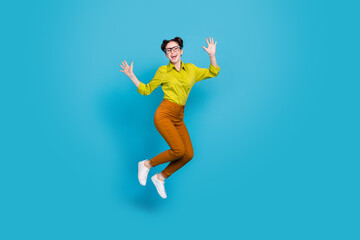 Fototapeta na wymiar Full length photo of crazy cheerful person jumping raise arms isolated on blue color background