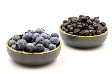 Raw and dried blueberries isolated on white background.Blueberries in bowl. Close-up.