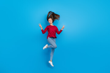 Full body photo of hooray young lady jump show v-sign wear eyewear shirt jeans shoes isolated on blue background