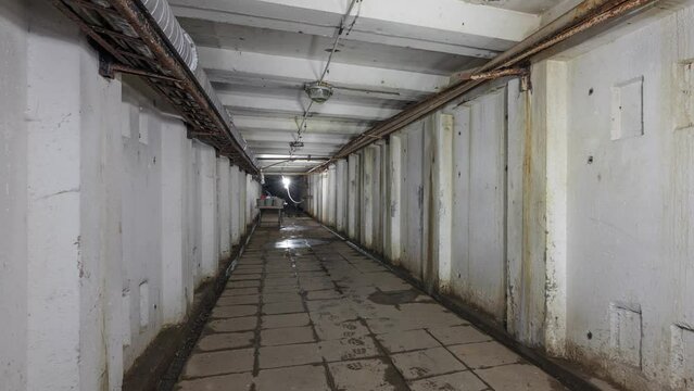 Long concrete underground corridor in an abandoned laboratory 