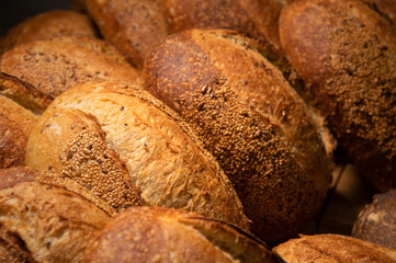 Sourdough bread close-up. Freshly baked round bread with golden crust on bakery shelves. The context of a German bakery with a rustic assortment of bread.