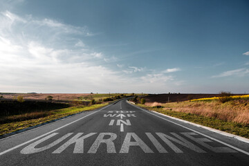 Empty road through the field with the text on the pavement Stop war in Ukraine