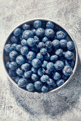 Top down shot of fresh blueberries picked into dish.