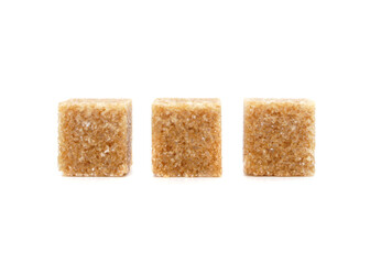 Pieces of Brown cane sugar isolated on white background. Three sugar cubes in a row.
