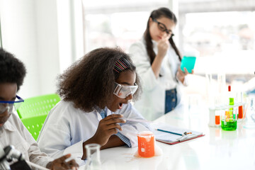 Group of teenage student learn science and study doing a chemical science experiment and holding test tube in hand in the experiment laboratory class on table at school.Education