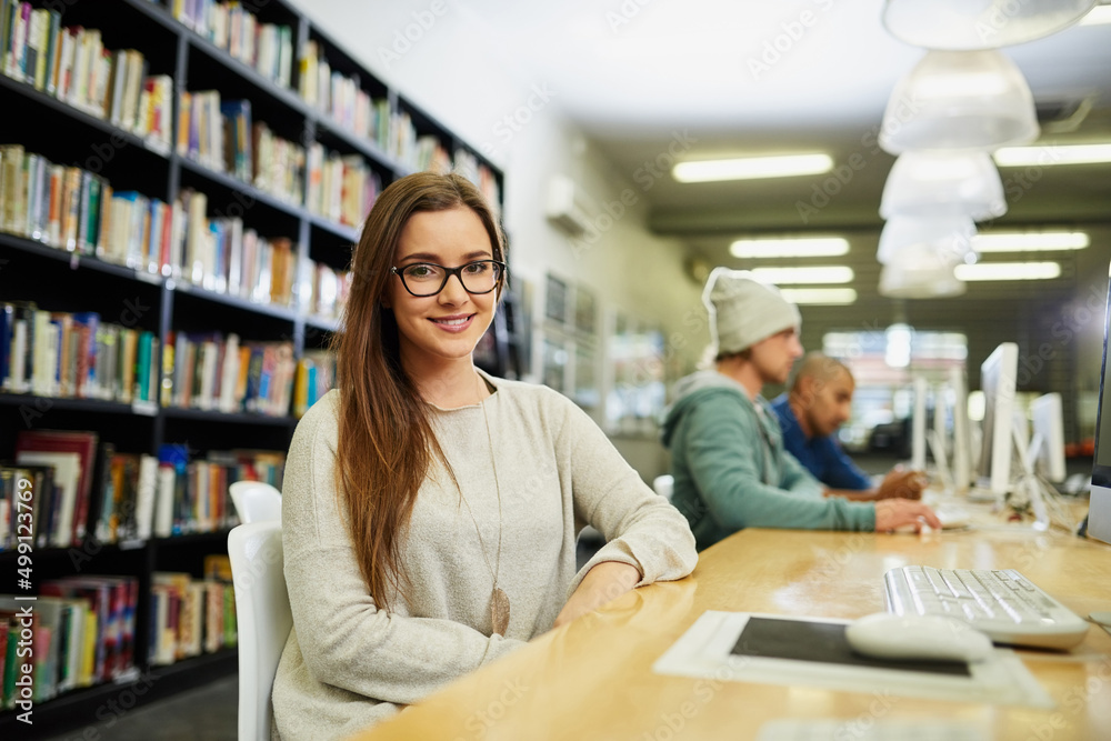 Poster studying is my number one priority. cropped portrait of a young female university student studying i