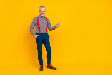 Fototapeta premium Full length body size view of attractive cheerful man demonstrating copy space isolated over bright yellow color background