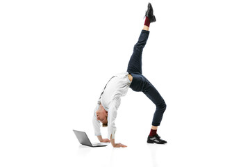 Creative portrait of young flexible man doing backbend and typing on laptop isolated over white studio background. Business in modern life concept