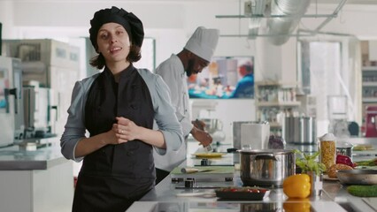 POV of female chef broadcasting cooking show on camera, creating culinary content in professional kitchen. Woman preparing food recipe for gastronomy TV program, cookery class. Tripod shot.