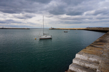 Boat in harbour under grey skies