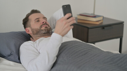 Man using Smartphone in Bed