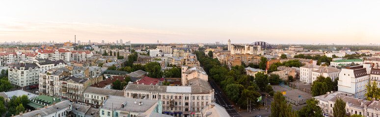 Fototapeta na wymiar Ukraine, Kyiv – July 04, 2015: Aerial panoramic view on central and historical part, area of city Podil with residential buildings in the evening, during the sunset. Pre-revolutionary buildings
