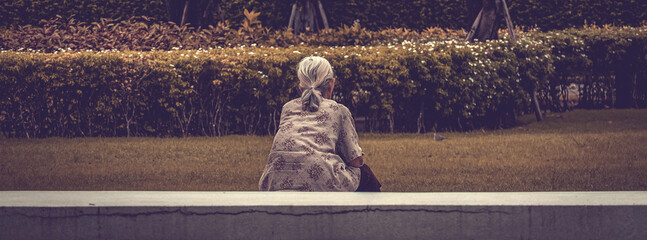 Asian elder senior woman sitting  at park. Grey hair, Old lady,  Feeling lonely, Aging society concept.