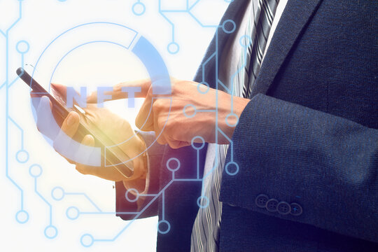 Concept of NFT and blockchain within the network. Businessman from his smartphone.