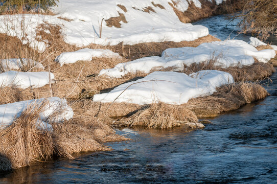 Snow melts in spring along the riverbank. Spring landscape.