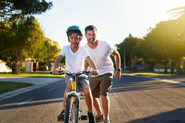 Obraz premium Cycling through his block. Shot of a young boy riding his bicycle through his neighbourhood.