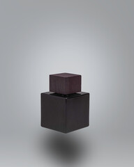 Dark luxury glass bottle floating on ultimate gray background. Minimal luxury and gift concept.