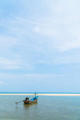 Traditional fishing boat on seaside with blue sky vertical