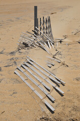 Blown down and partially buried wood storm fence on the sand dunes of the Outer Banks of North...