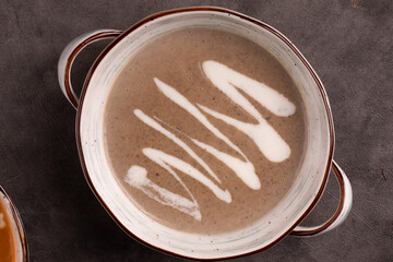Mushroom cream soup with heavy cream on the grey background