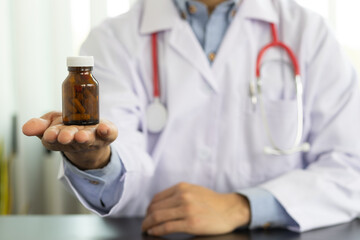 Doctor holding a bottle of medicine in a pharmaceutical research laboratory.