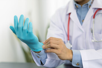 Doctor wearing medical gloves in the doctor's office.