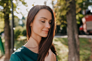 Close up portrait of lovely charming lady with dark hair closed eyes and gentle smiling
