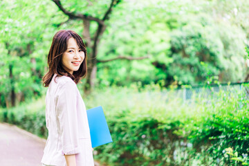 書類を持って歩く若いビジネスウーマン