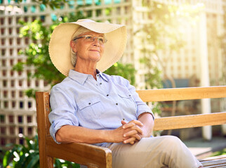 Retirement, a time for rest and reflection. Shot of a thoughtful senior woman relaxing on a bench in the garden.