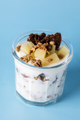 Healthy Trifle Layer Parfait with Yogurt White Milk Butter Cream Crust Oatmeal Topping and Ripe Fruit Blue Background