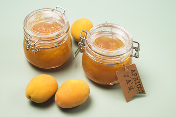 Homemade Jam from Apricots in a glass jar on a Green Background