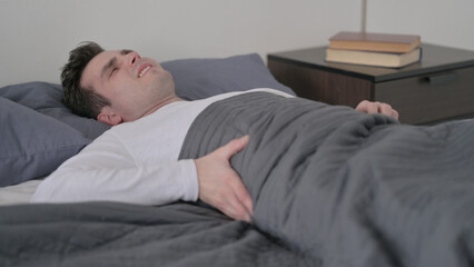 Obraz premium Man having Back Pain in Bed